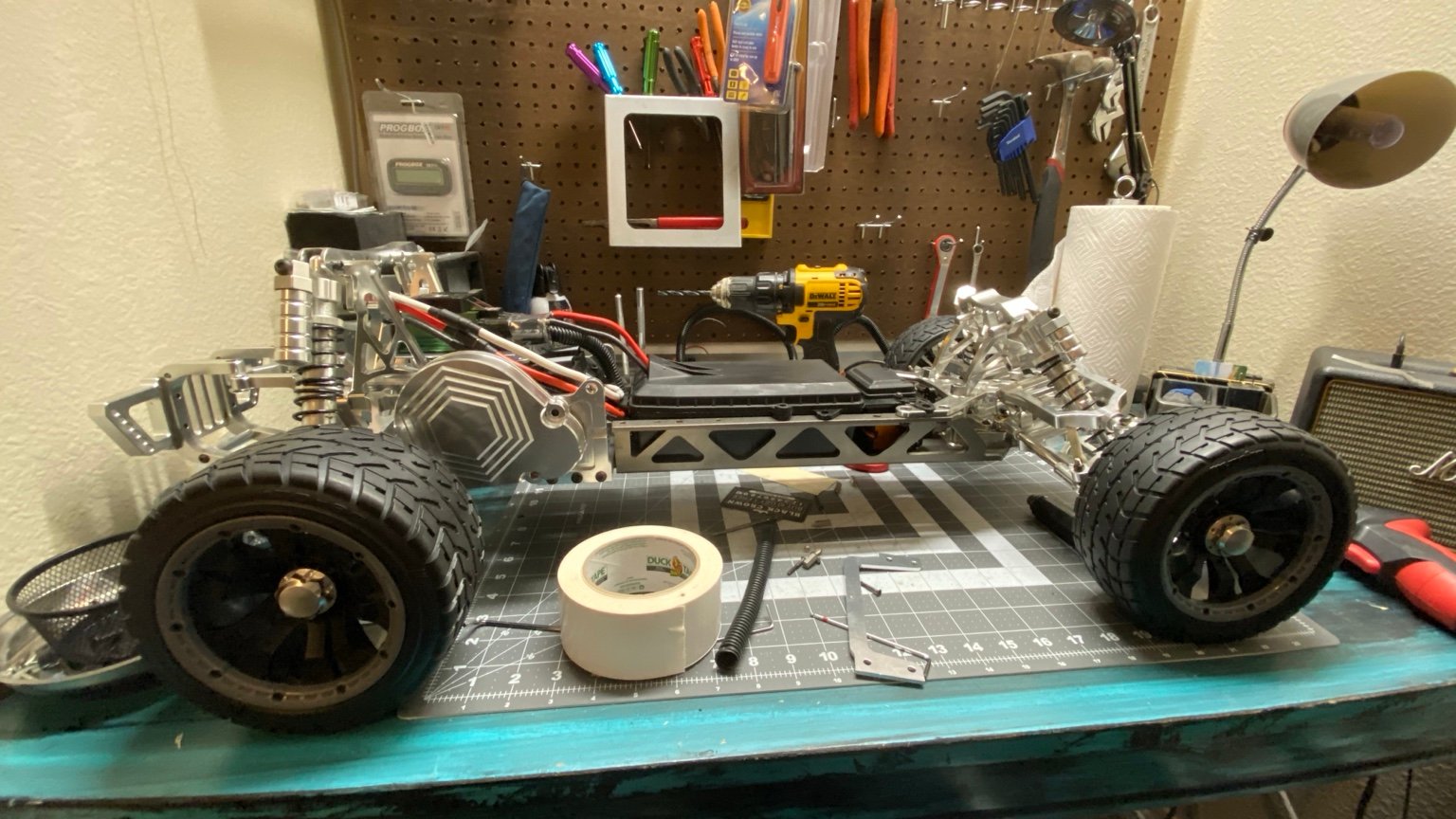 Full side view of a 1/5-scale aluminum Baja conversion on a workshop bench.